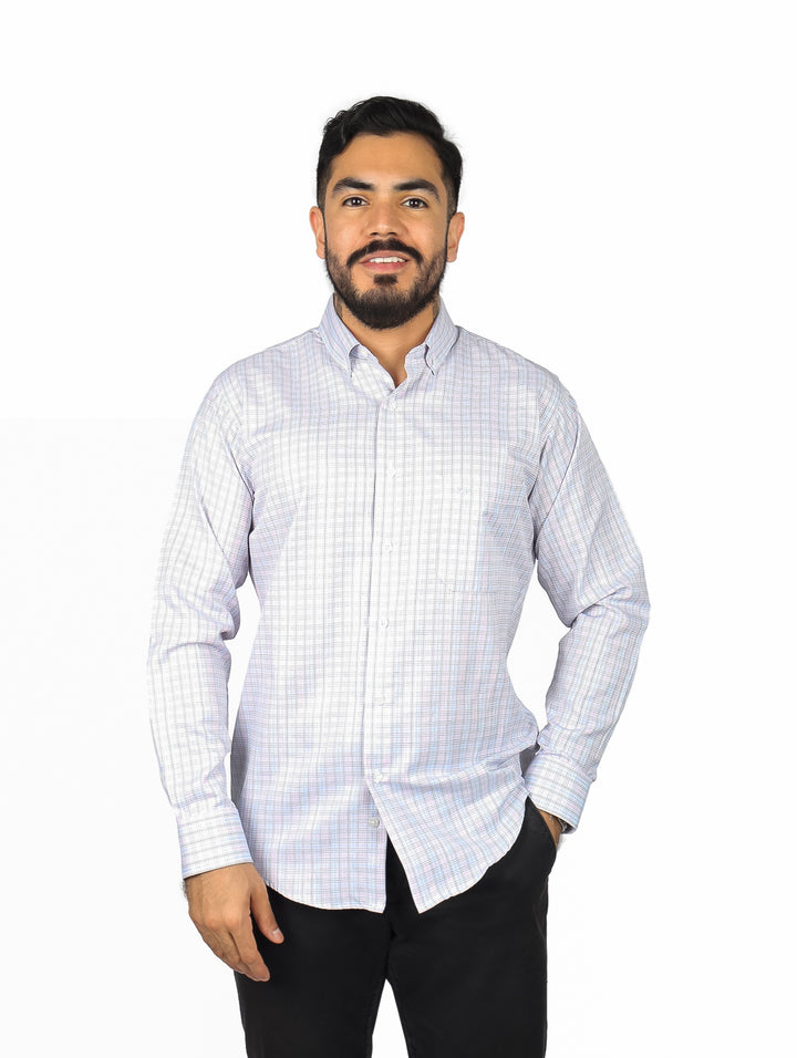 Hombre vistiendo una camisa de manga larga color rosa claro con patrón de cuadros pequeños y corte slim fit.