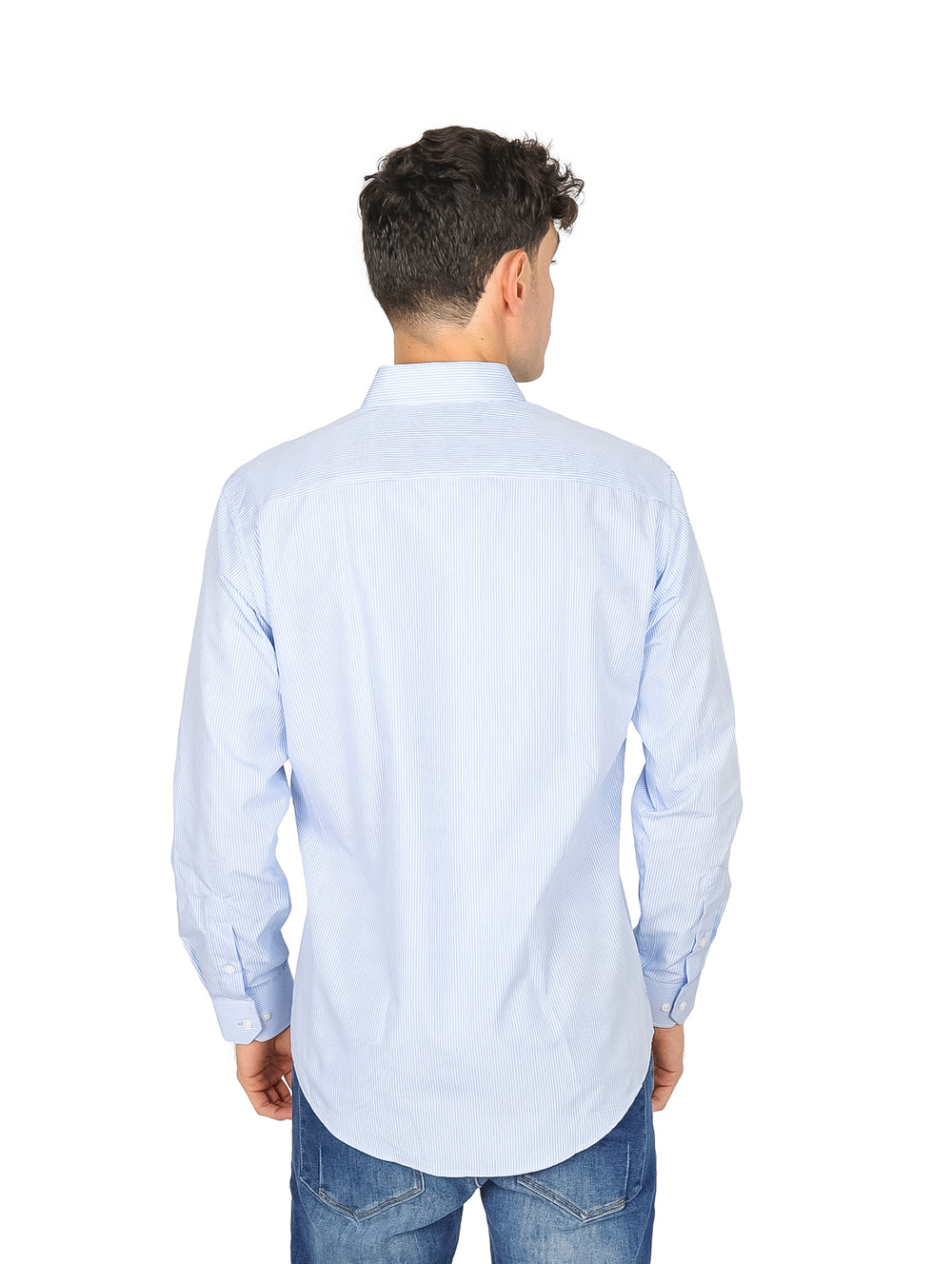 Hombre vistiendo una camisa slim fit de color azul claro con rayas blancas y pantalones vaqueros.