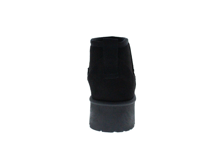 Bota corta de color negro con suela gruesa y dentada sobre fondo blanco.
