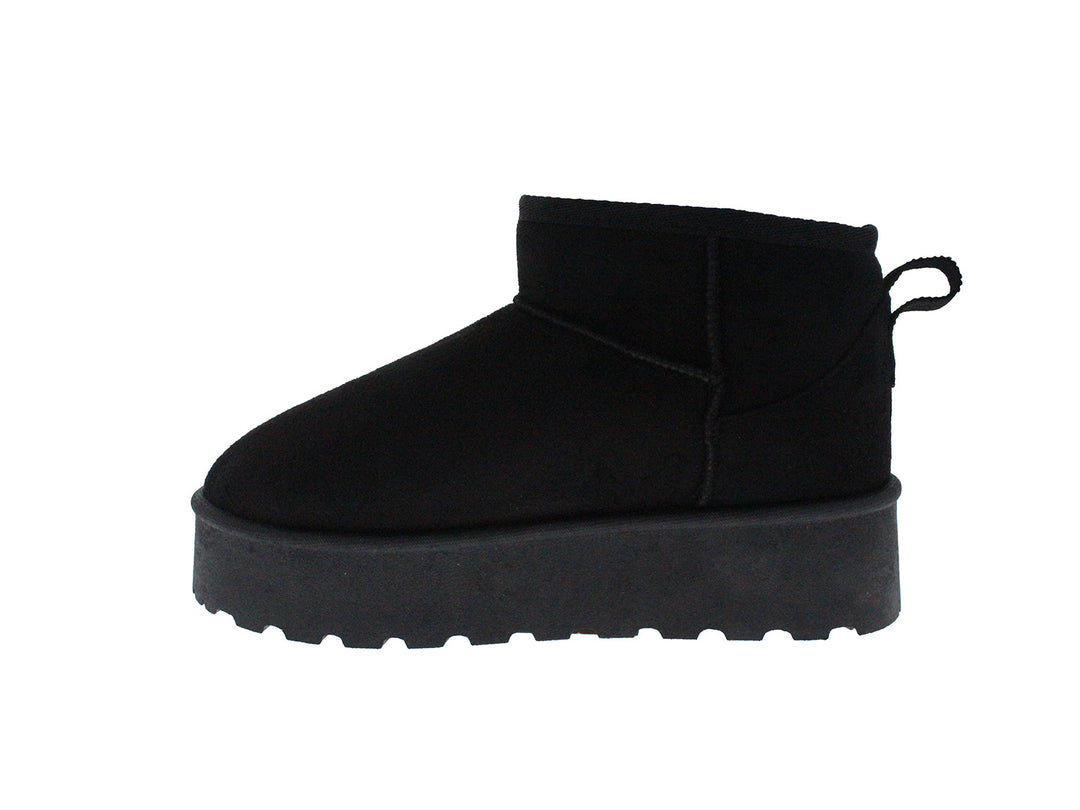 Bota corta de color negro con suela gruesa y dentada sobre fondo blanco.