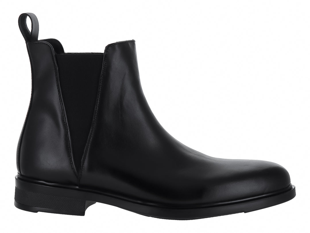 Bota tipo Chelsea de color negro con acabado brillante y elástico lateral.