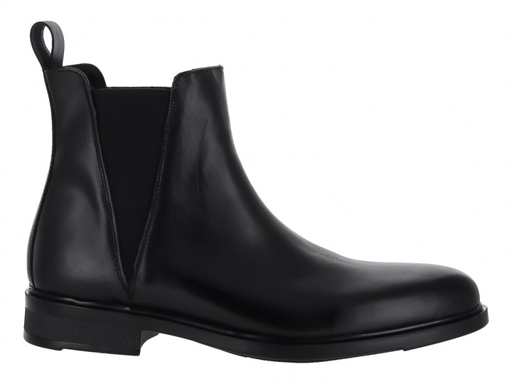 Bota tipo Chelsea de color negro con acabado brillante y elástico lateral.