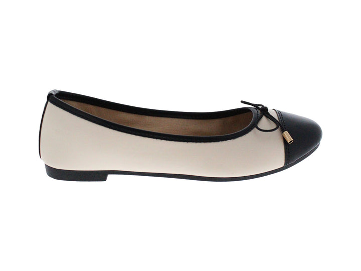 Zapatos planos estilo baletas en colores beige y negro con un pequeño lazo decorativo en la punta.