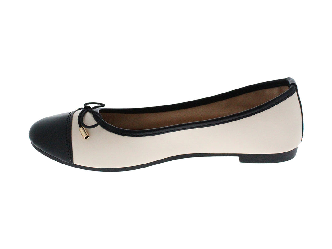 Zapatos planos estilo baletas en colores beige y negro con un pequeño lazo decorativo en la punta.