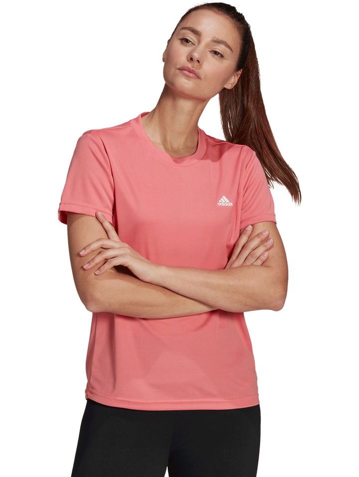 Mujer vistiendo playera deportiva Adidas color rosa con logo blanco en el pecho.