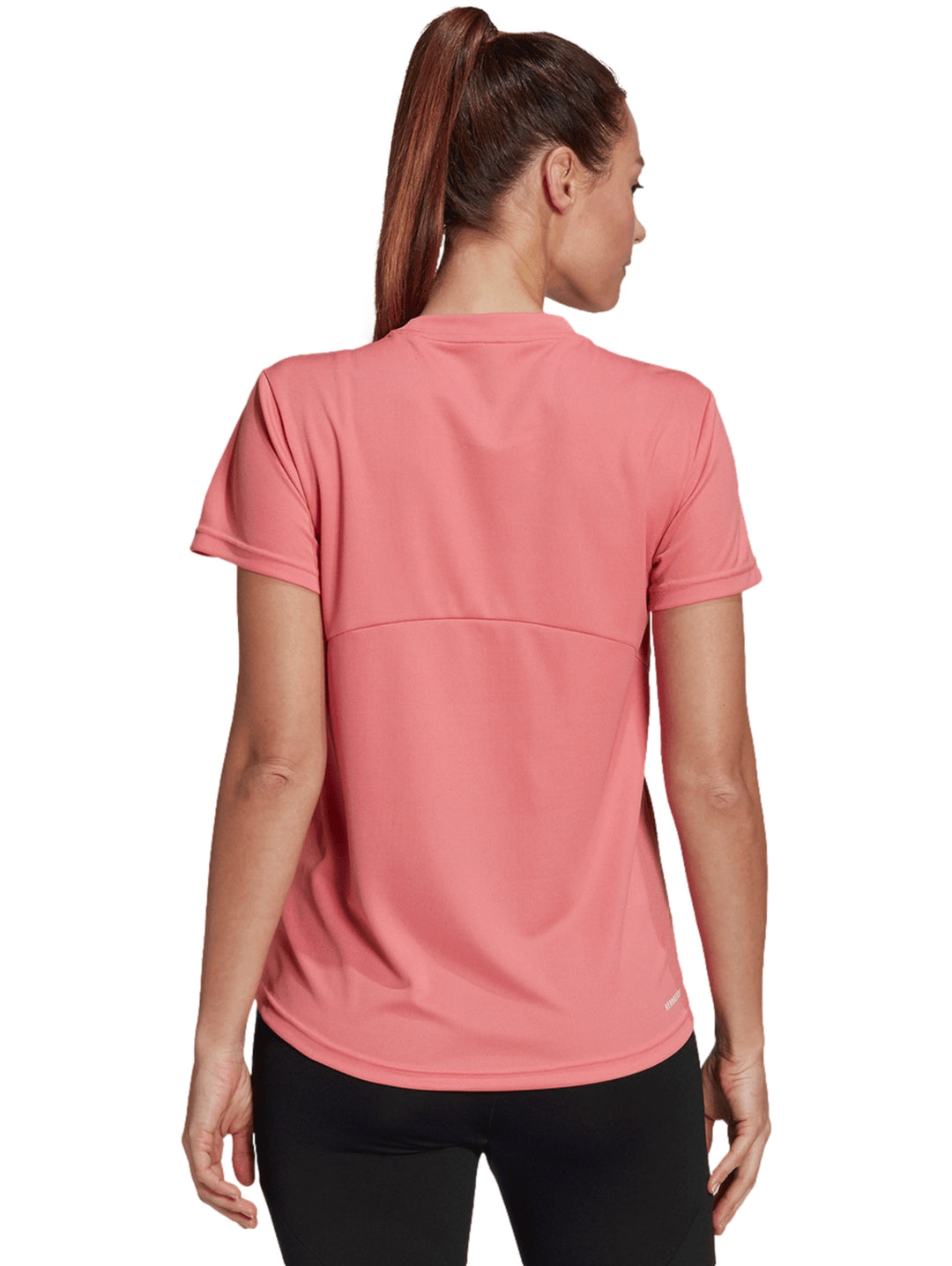 Mujer vistiendo playera deportiva Adidas color rosa con logo blanco en el pecho.