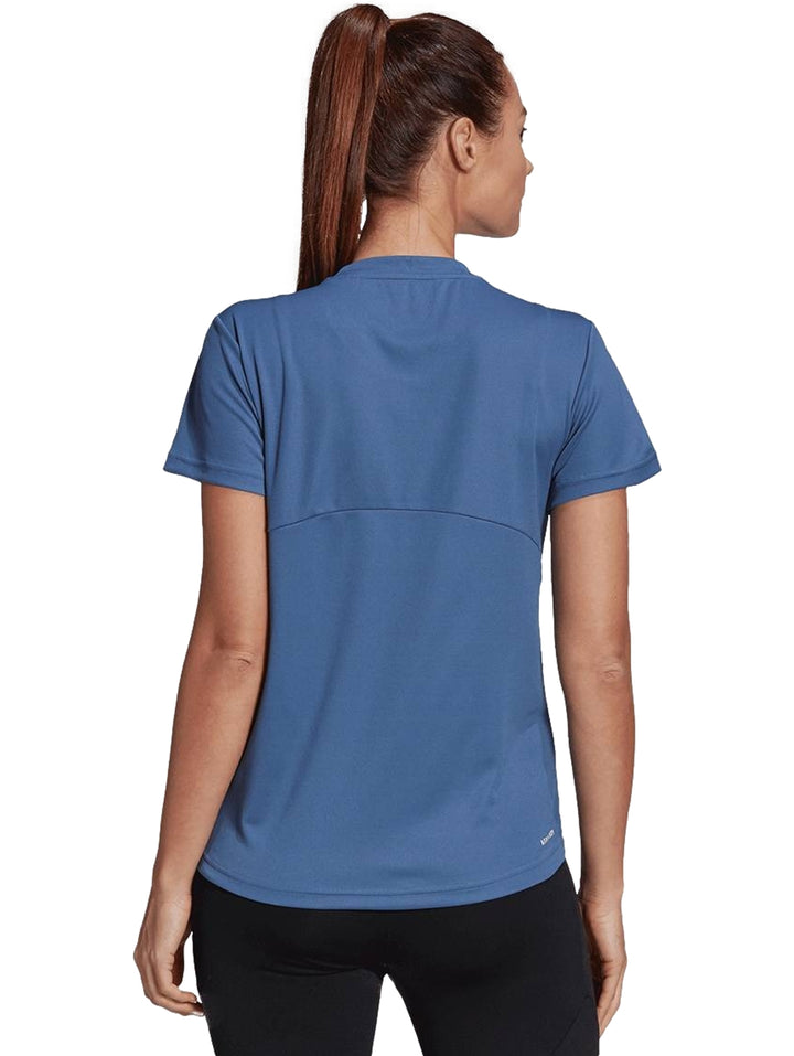 Mujer vistiendo playera deportiva Adidas de color azul con manga corta y cuello redondo.