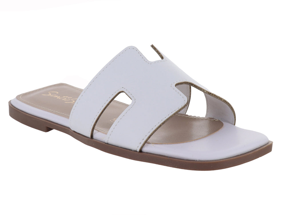 Sandalia slide blanca de cuero con suela marrón.