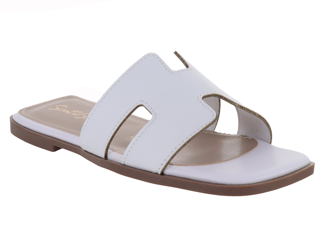 Sandalia slide blanca de cuero con suela marrón.