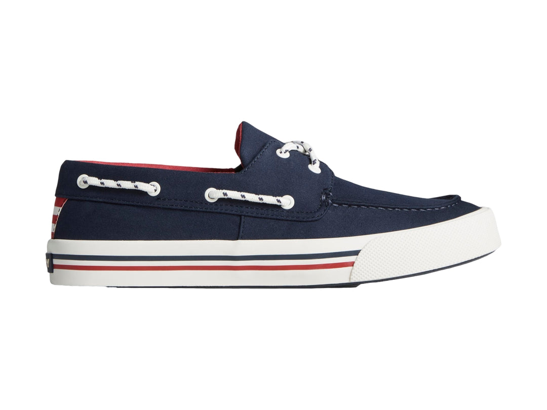 Zapato náutico Sperry azul marino con suela blanca y detalles rojos.