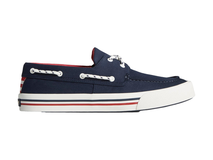 Zapato náutico Sperry azul marino con suela blanca y detalles rojos.