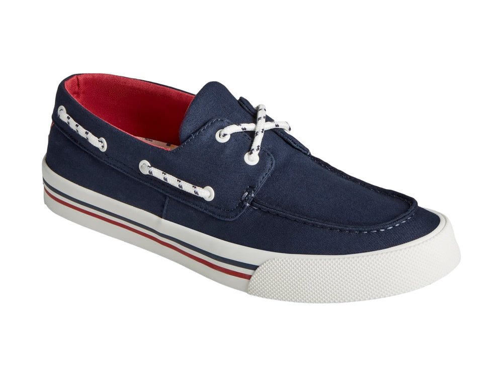 Zapato náutico Sperry azul marino con suela blanca y detalles rojos.