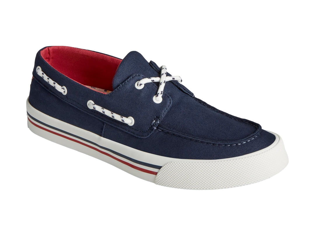 Zapato náutico Sperry azul marino con suela blanca y detalles rojos.