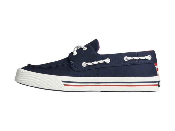 Zapato náutico Sperry azul marino con suela blanca y detalles rojos.