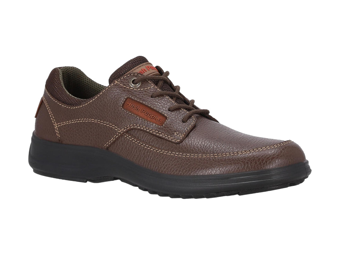 Zapato casual Hush Puppies de cuero marrón con suela negra y cordones.