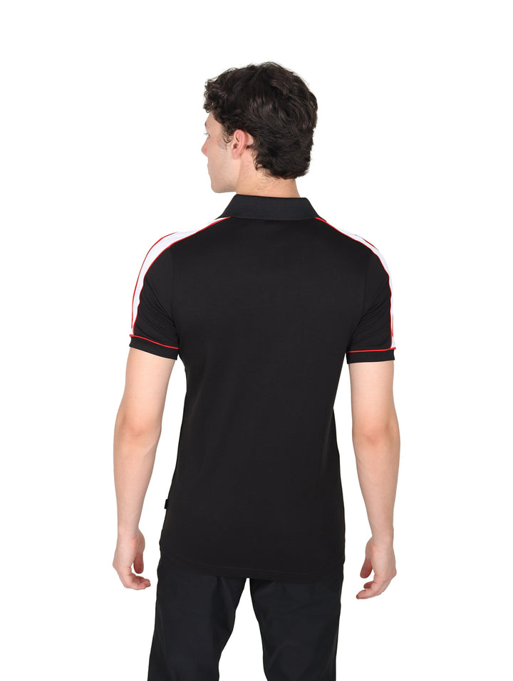 Hombre vistiendo playera polo color negro con detalles en rojo y blanco y cierre frontal.