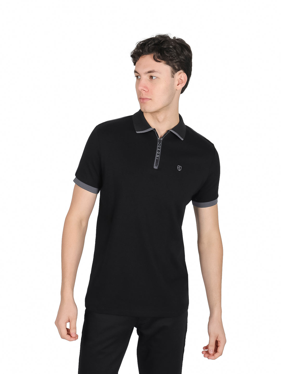 Hombre vistiendo playera polo color negro con detalles en gris oxford en cuello y mangas.
