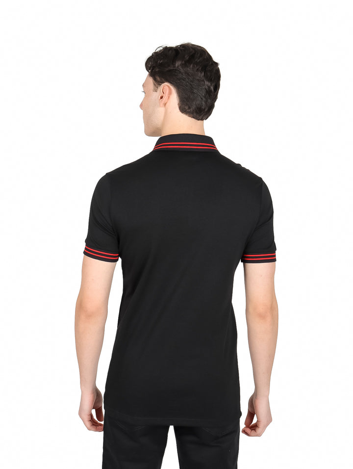 Hombre vistiendo playera polo negra con detalles rojos en mangas y cierre.