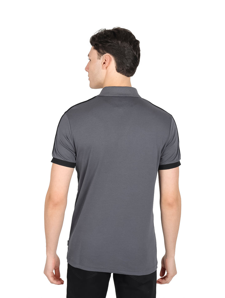 Playera polo color gris oxford con cuello y puños negros y cierre frontal.