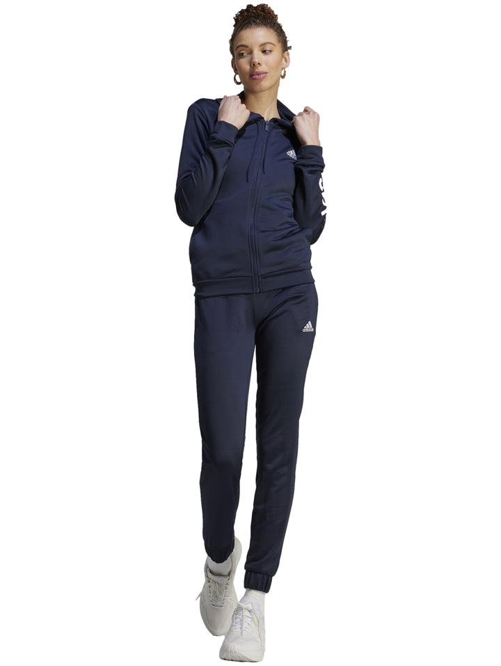 Mujer vistiendo un conjunto deportivo Adidas de color azul marino compuesto por chaqueta y pantalón.