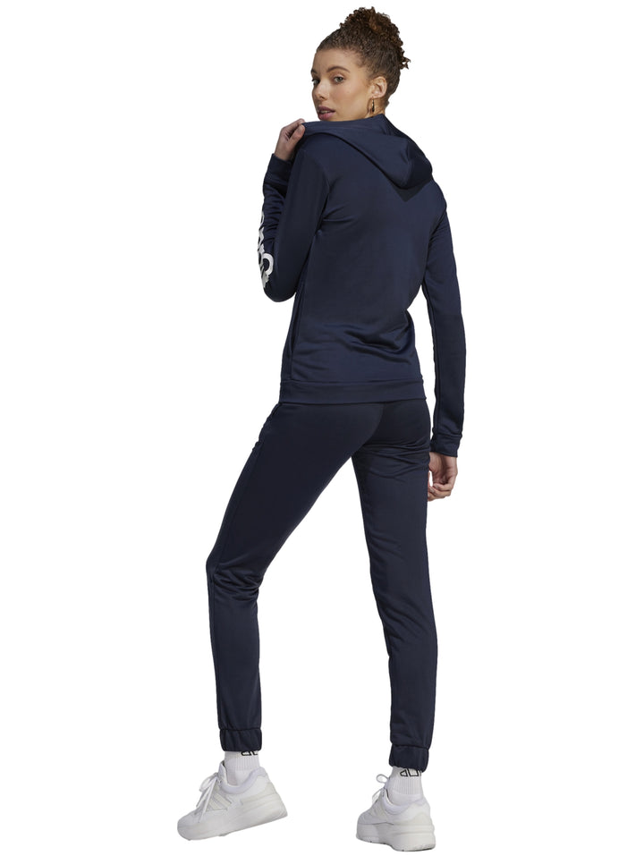 Mujer vistiendo un conjunto deportivo Adidas de color azul marino compuesto por chaqueta y pantalón.