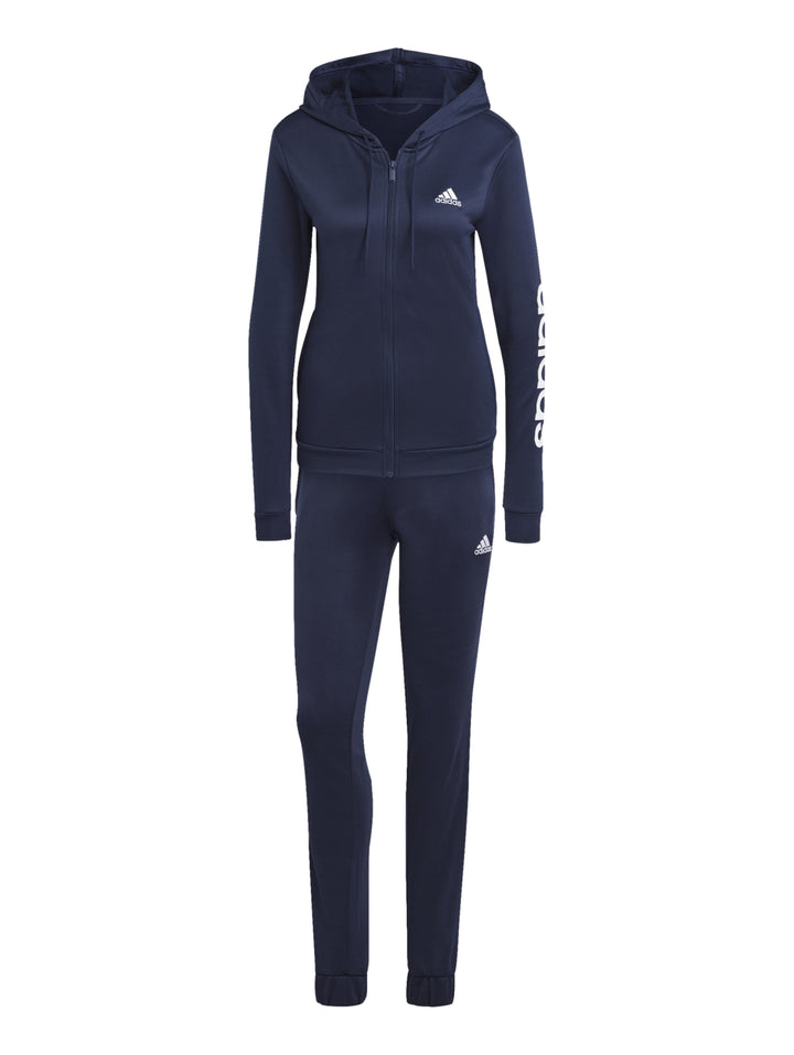 Mujer vistiendo un conjunto deportivo Adidas de color azul marino compuesto por chaqueta y pantalón.