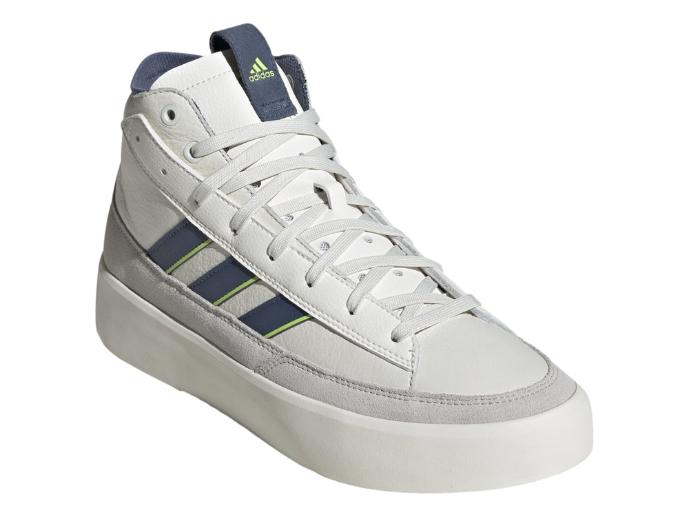 Tenis Adidas blancos de corte alto con franjas azul marino y verde lima y base gris.