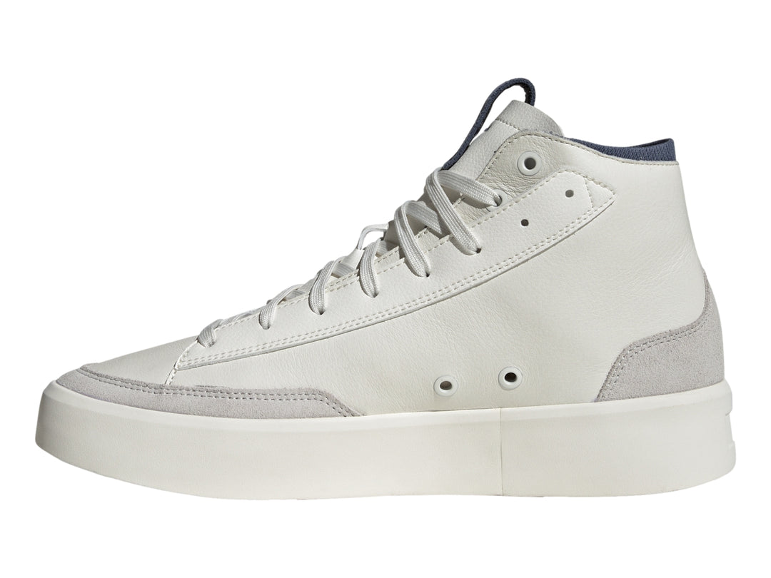 Tenis Adidas blancos de corte alto con franjas azul marino y verde lima y base gris.