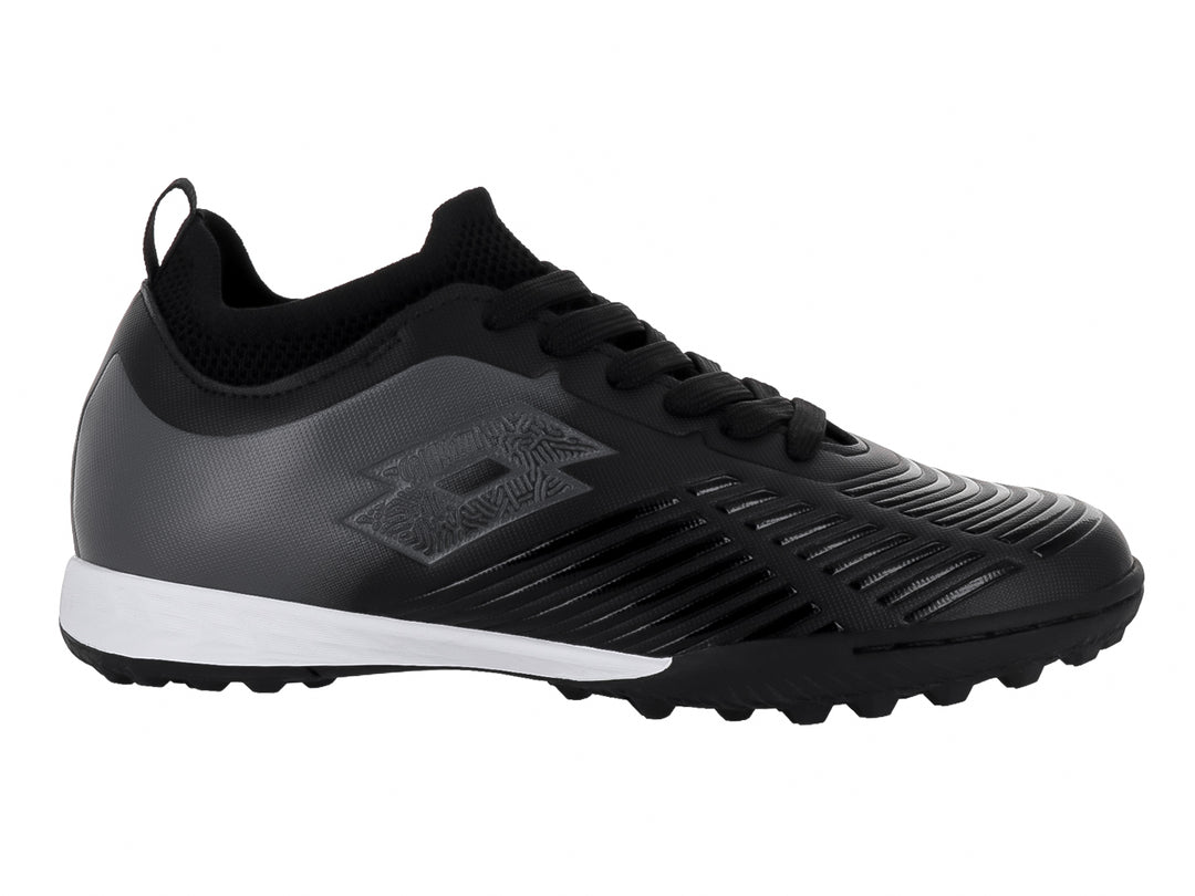 Zapato de fútbol Lotto color negro con suela blanca y detalles lineales en el empeine para niños.