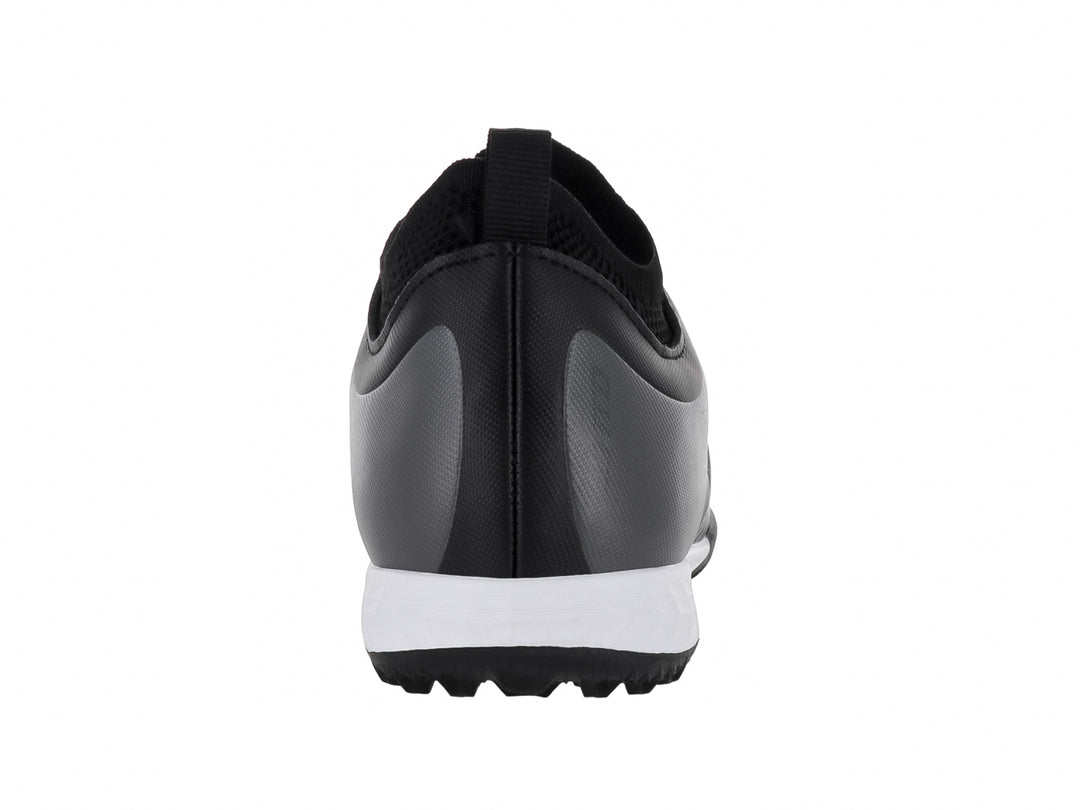 Zapato de fútbol Lotto color negro con suela blanca y detalles lineales en el empeine para niños.