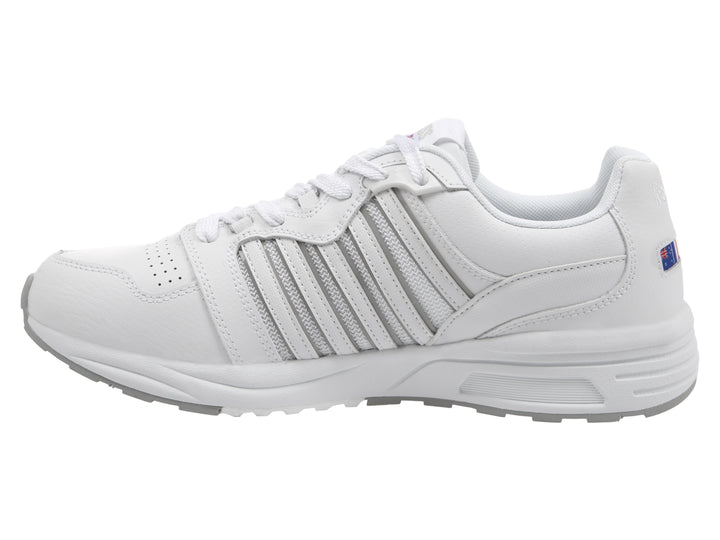 Tenis deportivos K-Swiss en color blanco con suela gris y detalles lineales laterales.