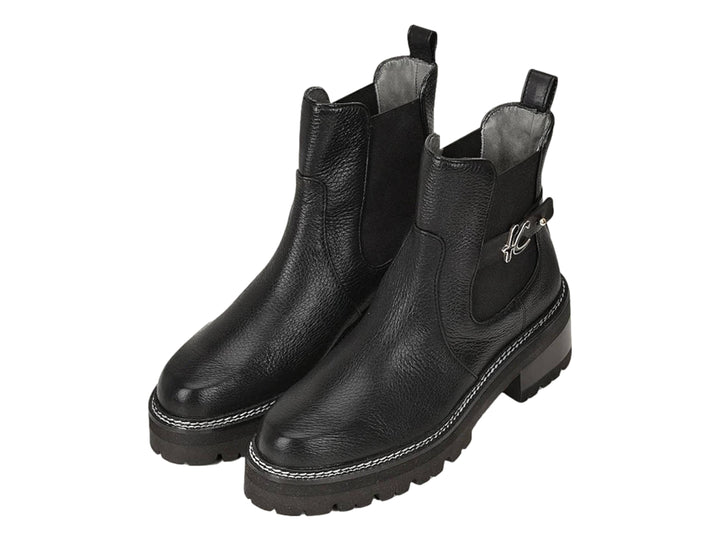 Bota de cuero negro con suela track y detalle de hebilla plateada.