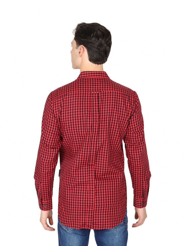Hombre vistiendo una camisa de cuadros rojos y negros de manga larga.