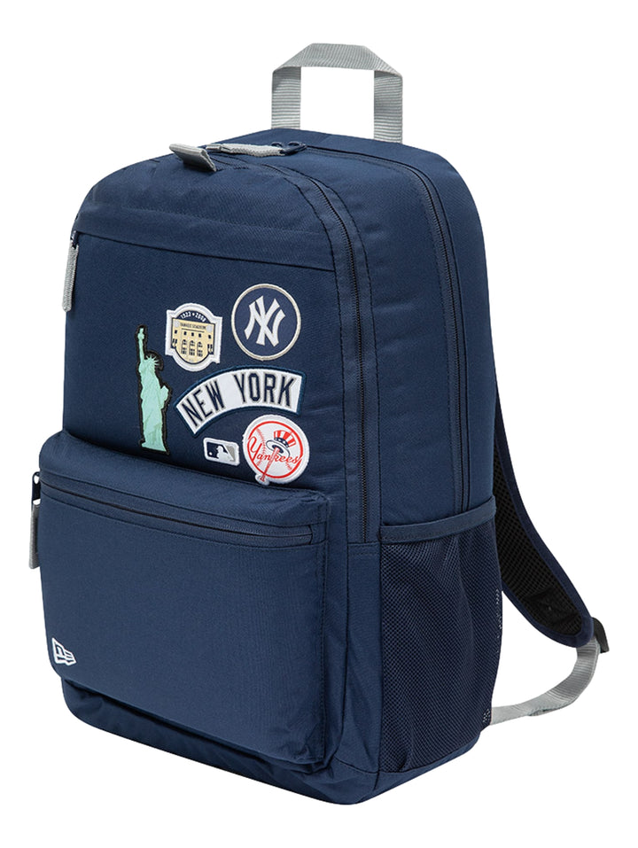 Mochila New Era color navy con parches decorativos de Nueva York y los Yankees, con asa gris y bolsillo lateral de malla.