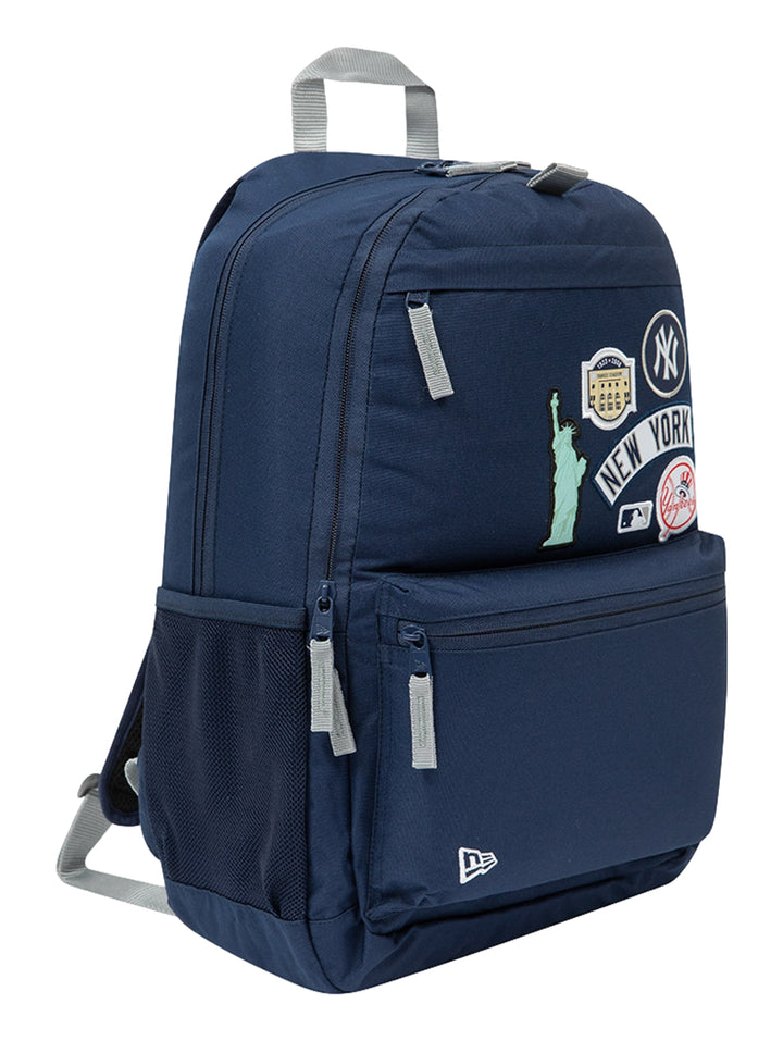 Mochila New Era color navy con parches decorativos de Nueva York y los Yankees, con asa gris y bolsillo lateral de malla.