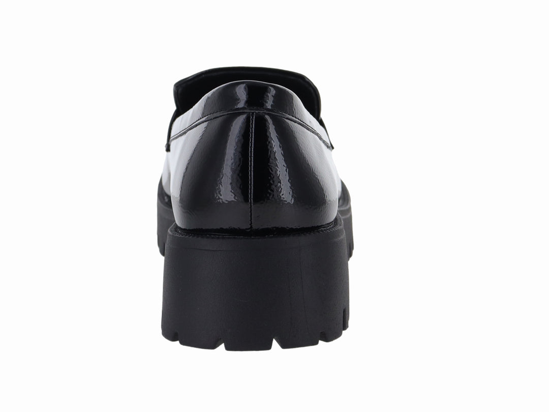 Mocasín negro de charol con suela track gruesa y detalle dorado en la parte superior.