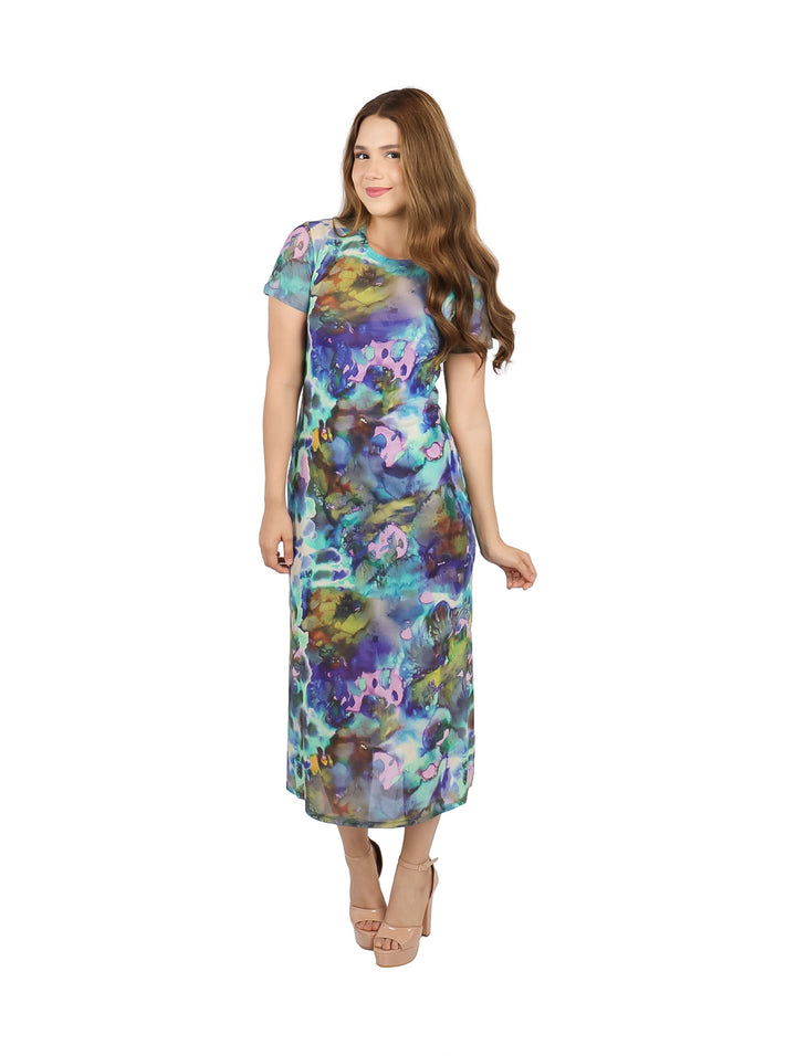 Mujer con vestido midi de manga corta y estampado multicolor estilo acuarela en tonos azules y púrpuras.