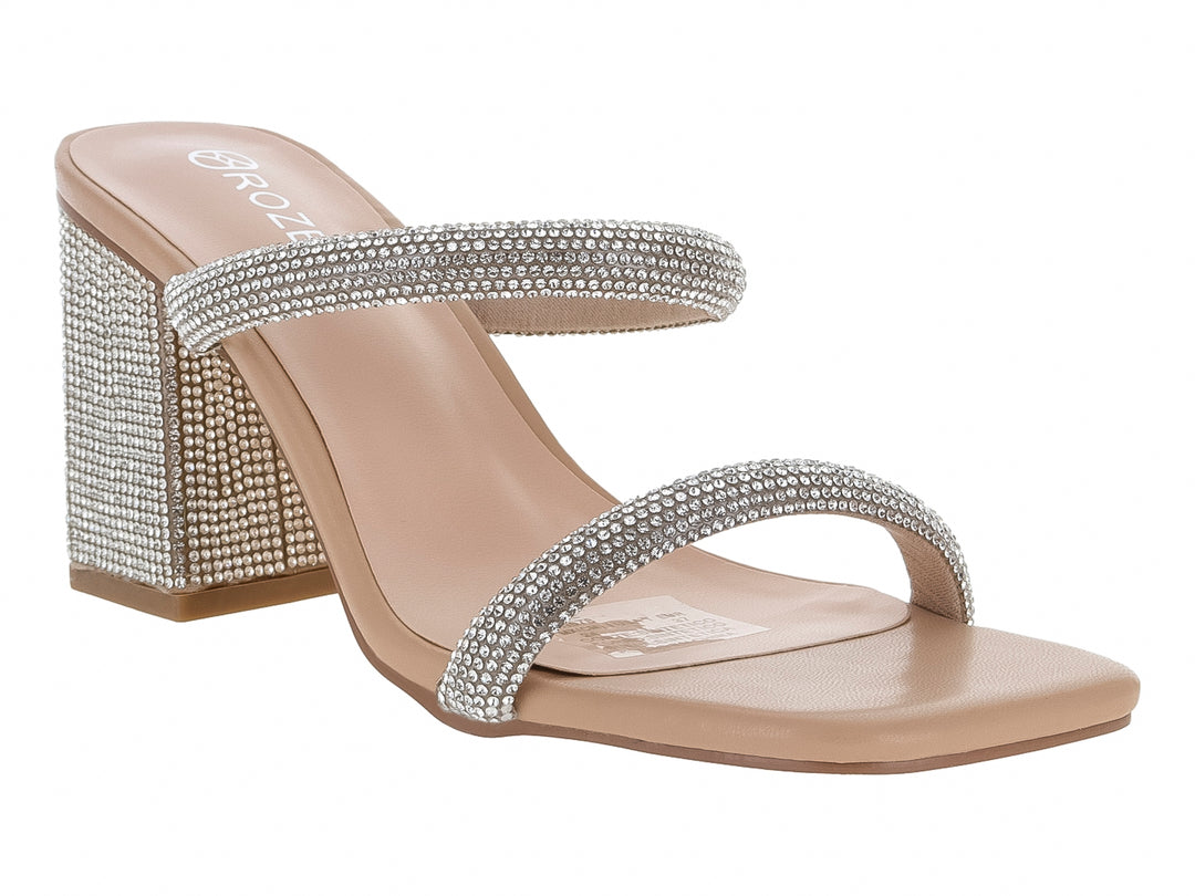 Sandalias beige de tacón cuadrado adornadas con tiras y tacón cubierto de pedrería plateada brillante.