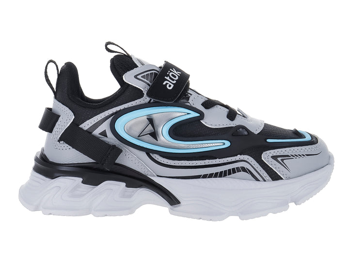 Tenis deportivos infantiles color gris y negro con suela blanca gruesa y detalles en azul claro.