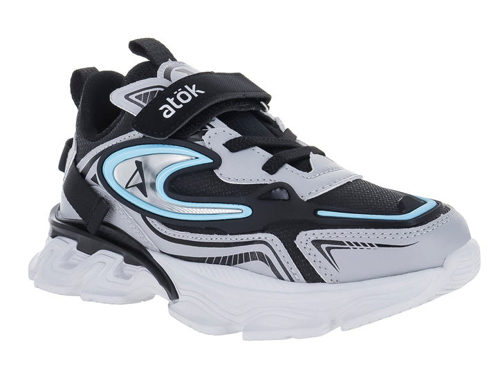 Tenis deportivos infantiles color gris y negro con suela blanca gruesa y detalles en azul claro.