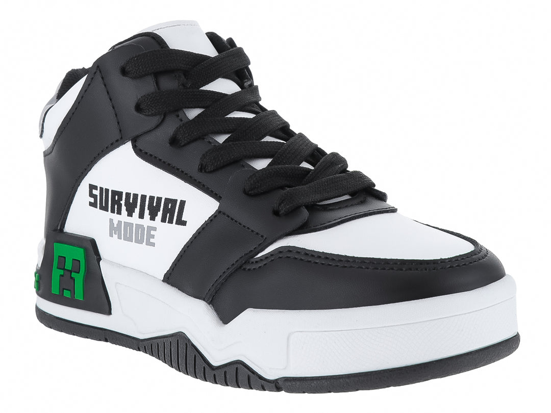 Tenis infantiles color negro y blanco con detalles verdes pixelados y texto Survival Mode.