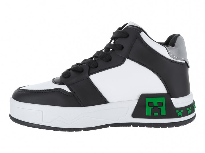 Tenis infantiles color negro y blanco con detalles verdes pixelados y texto Survival Mode.
