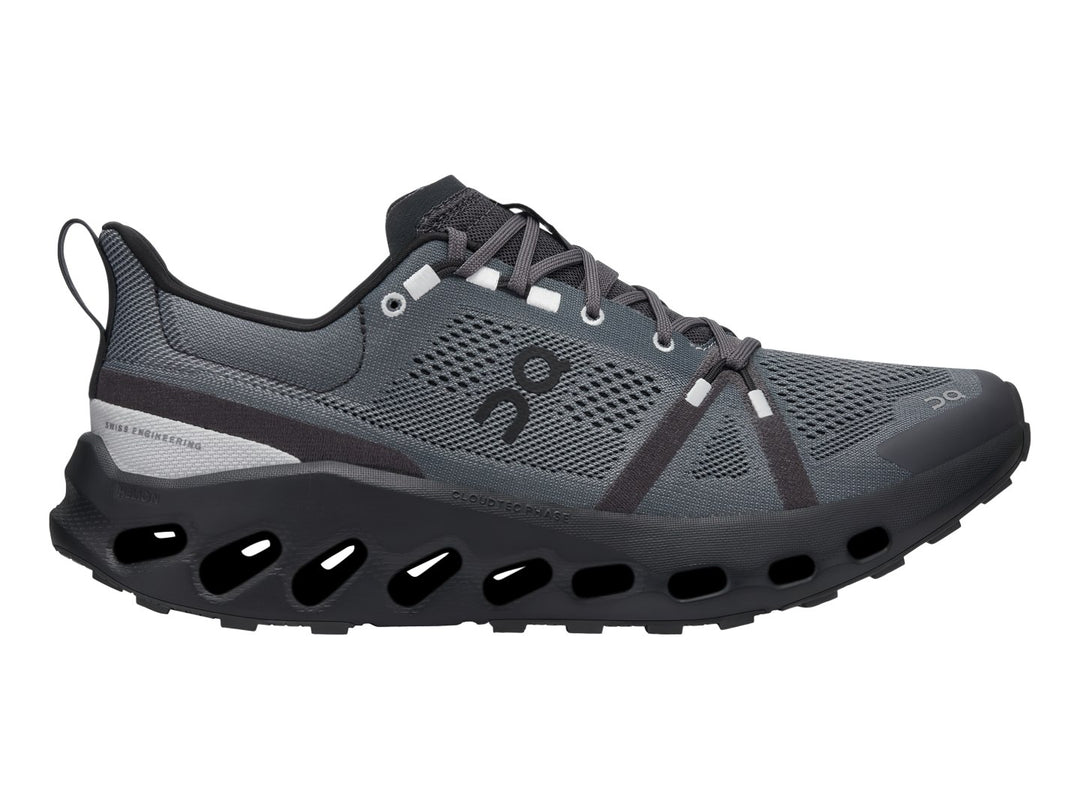 Zapato deportivo On Cloud Cloudsurfer Trail en color negro y gris con suela tecnológica amortiguada.