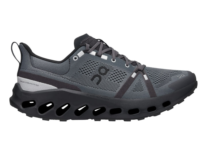 Zapato deportivo On Cloud Cloudsurfer Trail en color negro y gris con suela tecnológica amortiguada.