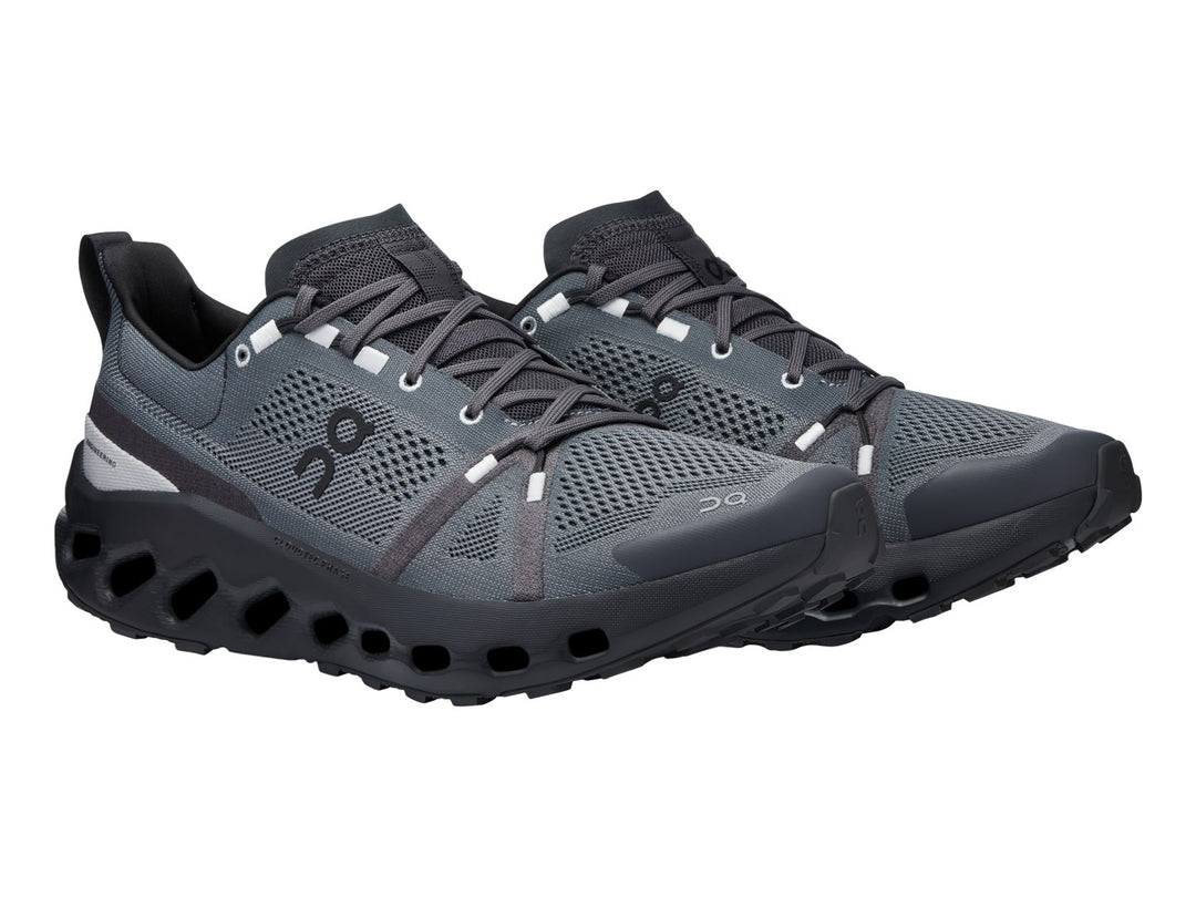 Zapato deportivo On Cloud Cloudsurfer Trail en color negro y gris con suela tecnológica amortiguada.
