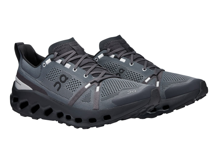 Zapato deportivo On Cloud Cloudsurfer Trail en color negro y gris con suela tecnológica amortiguada.