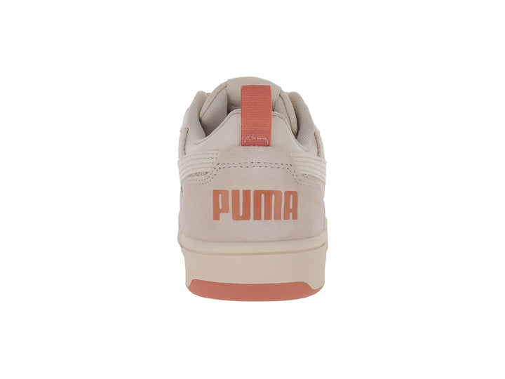 Tenis PUMA Rebound V6 Low en color blanco nieve con detalles en durazno, diseño deportivo de corte bajo.