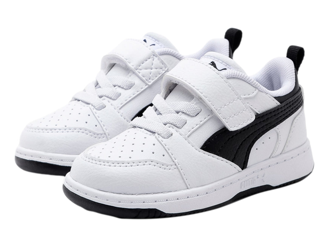 Tenis PUMA Rebound V6 Lo AC+ infantiles en color blanco con detalles laterales en negro y cierre de velcro.