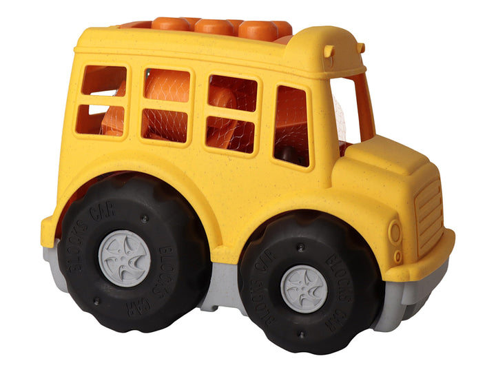 Juguete de autobús escolar amarillo con ruedas negras grandes, presentado en su empaque de cartón.
