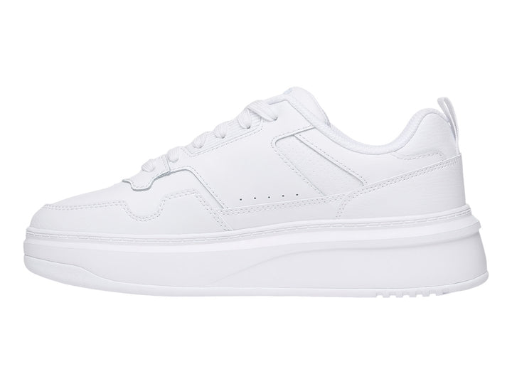 Tenis FILA blancos de plataforma baja con suela gruesa y diseño minimalista.